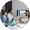 Team of professionals analyzing data on a monitor during a business meeting